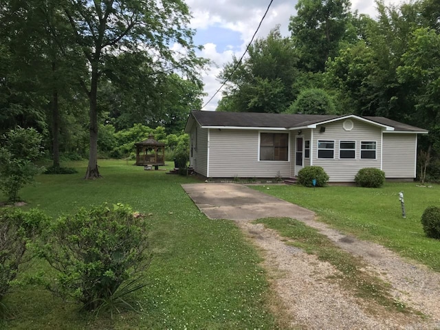 view of front of property featuring concrete driveway and a front lawn