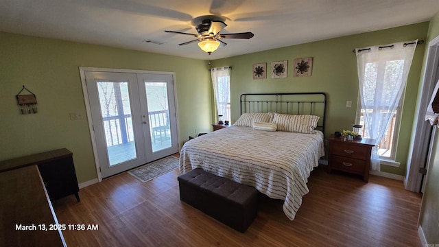 bedroom with visible vents, multiple windows, wood finished floors, and access to outside