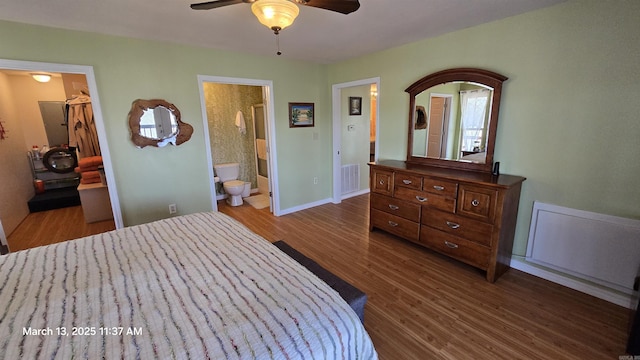 bedroom with a spacious closet, visible vents, connected bathroom, baseboards, and dark wood-style floors