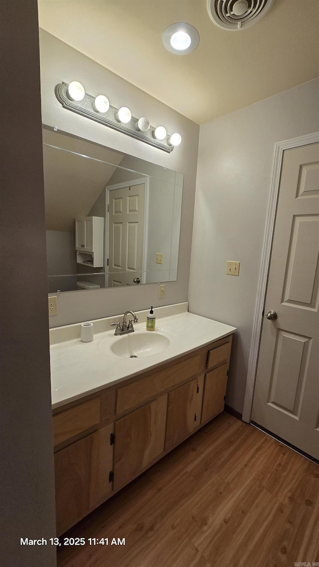 bathroom featuring visible vents, wood finished floors, and vanity