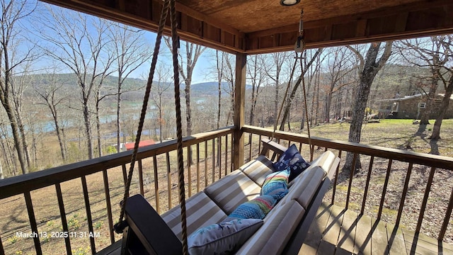 wooden terrace with a forest view, a mountain view, and an outdoor hangout area