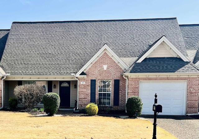 view of front of house with driveway, brick siding, an attached garage, and a shingled roof