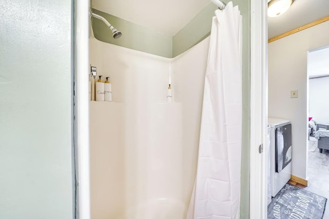 full bath with washing machine and clothes dryer and a shower with curtain