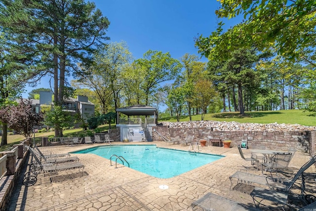 pool featuring a gazebo, fence, a lawn, and a patio area