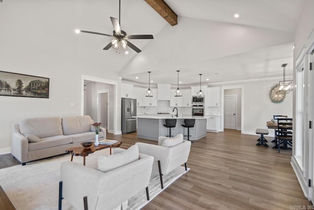 living room featuring baseboards, beamed ceiling, ceiling fan with notable chandelier, wood finished floors, and high vaulted ceiling