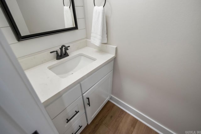 bathroom with vanity, baseboards, and wood finished floors