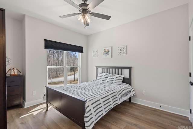 bedroom featuring ceiling fan, baseboards, and wood finished floors