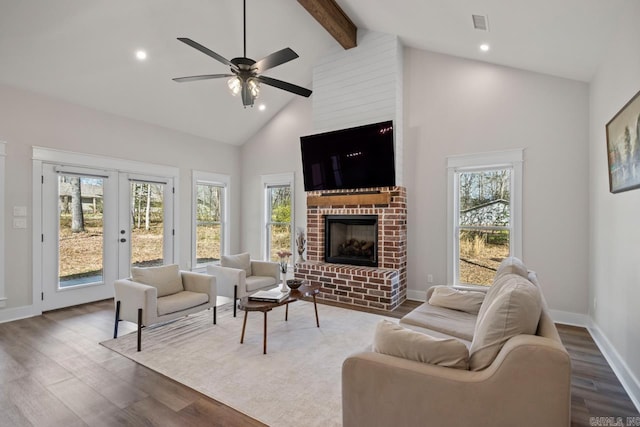 living room featuring a ceiling fan, high vaulted ceiling, a fireplace, dark wood-type flooring, and beamed ceiling