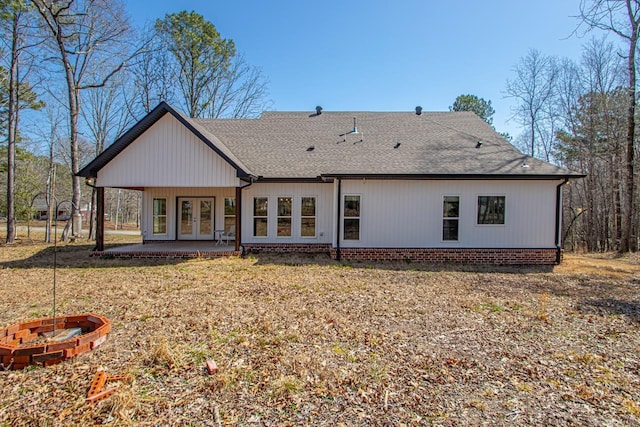 back of house featuring a shingled roof, a patio area, french doors, and an outdoor fire pit