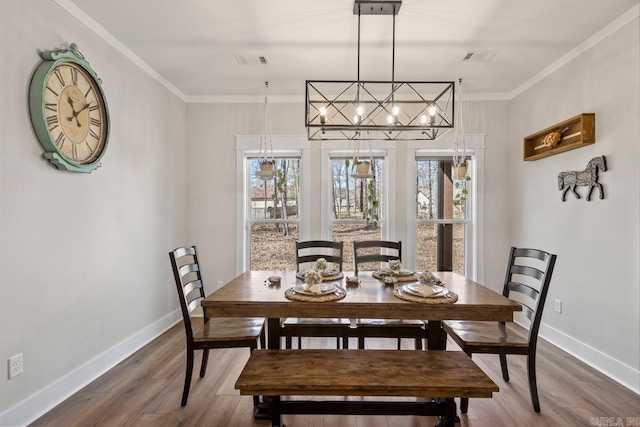 dining space with a wealth of natural light, wood finished floors, and ornamental molding