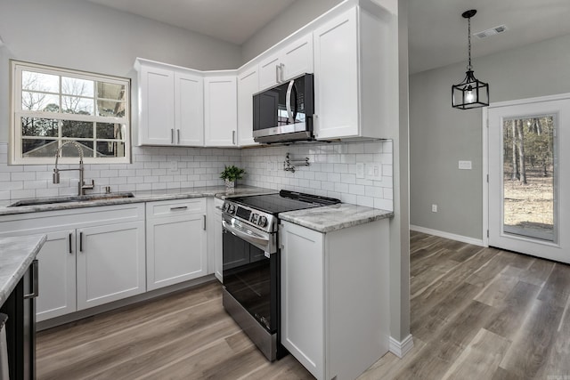 kitchen featuring visible vents, plenty of natural light, stainless steel appliances, and a sink