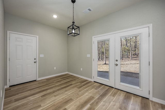 doorway to outside with light wood-style flooring, french doors, visible vents, and baseboards