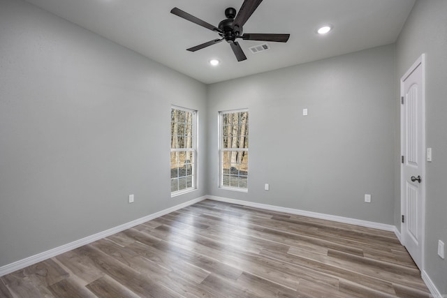 empty room with a ceiling fan, wood finished floors, baseboards, visible vents, and recessed lighting