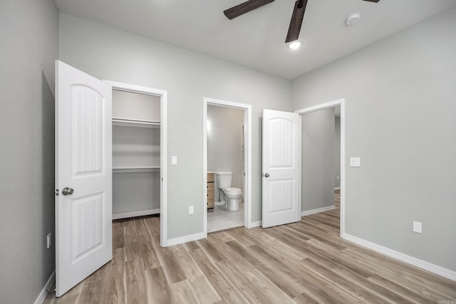 unfurnished bedroom featuring a spacious closet, connected bathroom, light wood-type flooring, and a closet