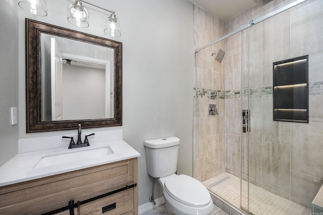 full bathroom with vanity, a shower stall, and toilet