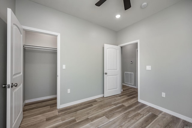 unfurnished bedroom with visible vents, wood finished floors, a closet, baseboards, and ceiling fan