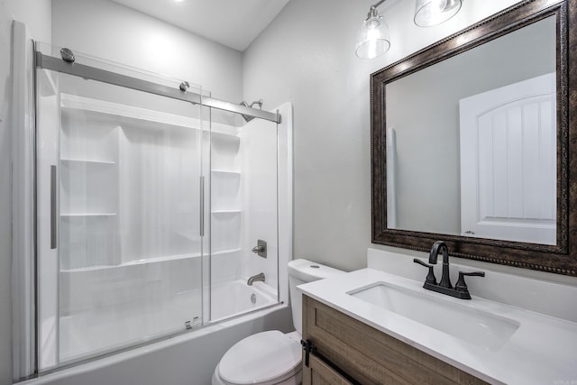 bathroom with vanity, toilet, and bath / shower combo with glass door