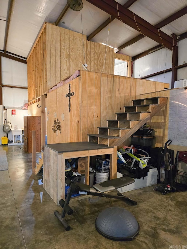 stairway featuring concrete floors and wood walls