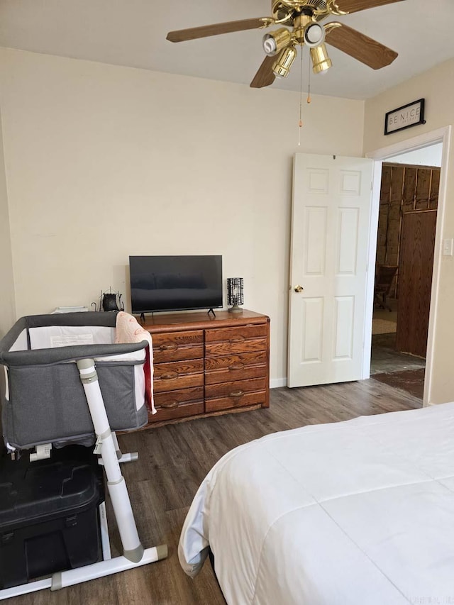 bedroom with ceiling fan, baseboards, and wood finished floors