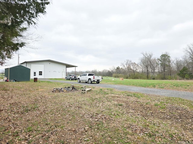 view of yard with an outbuilding, a detached garage, and an outdoor structure