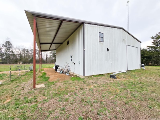 view of pole building with a carport and a yard