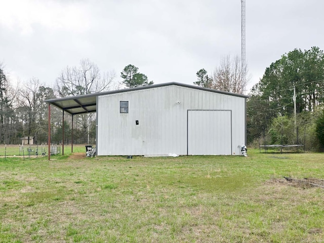 view of pole building with a trampoline and a lawn