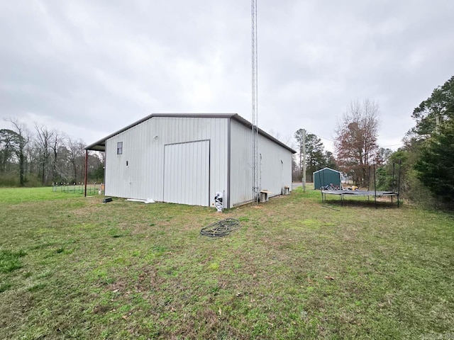 view of pole building featuring a lawn and a trampoline