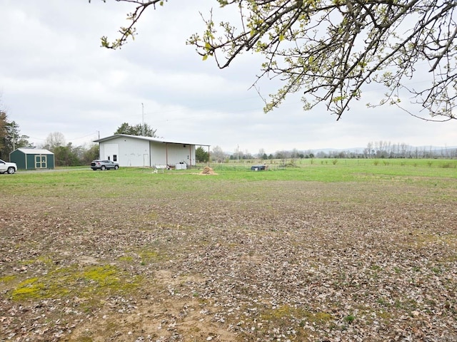 view of yard with an outbuilding and a rural view