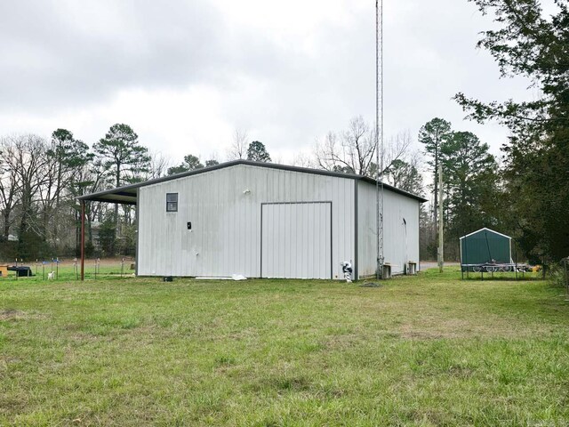 view of pole building with a trampoline and a yard