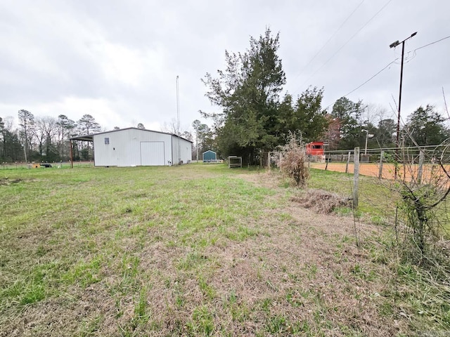 view of yard featuring a garage, an outbuilding, an outdoor structure, and fence