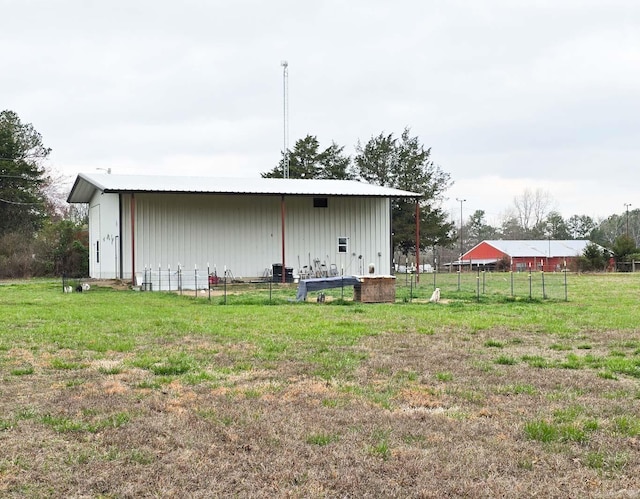 view of pole building with a lawn and fence