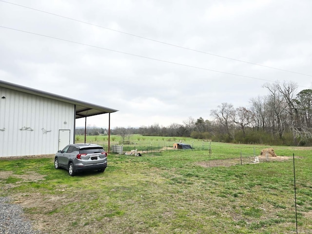 view of yard with a rural view, an outdoor structure, and a pole building