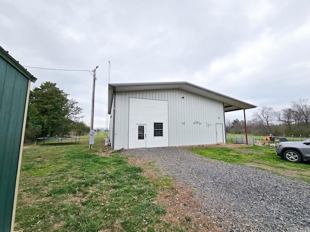 view of pole building featuring a lawn and a trampoline