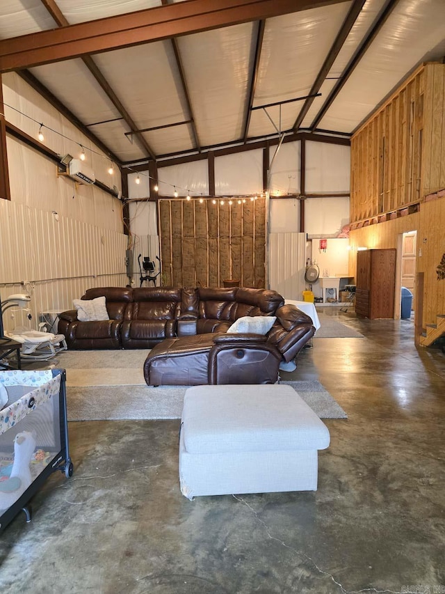 interior space with high vaulted ceiling, concrete floors, and a garage