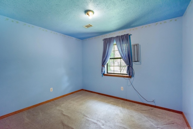 unfurnished room with visible vents, carpet floors, a textured ceiling, and baseboards