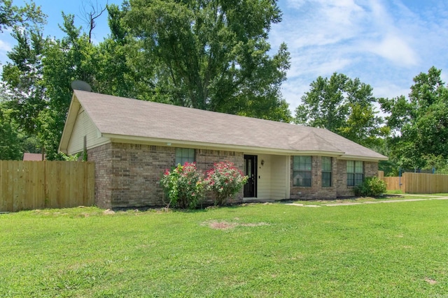 ranch-style home featuring brick siding, a front yard, and fence