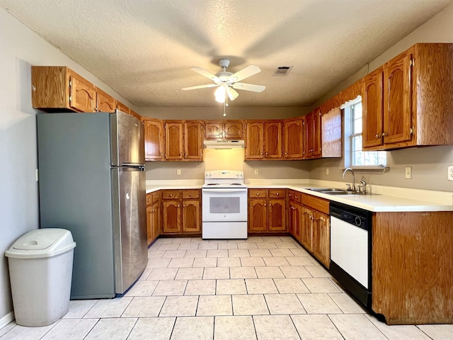 kitchen with white appliances, a ceiling fan, visible vents, a sink, and brown cabinets