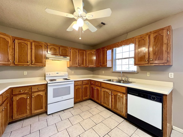 kitchen with brown cabinets, a ceiling fan, a sink, under cabinet range hood, and white appliances