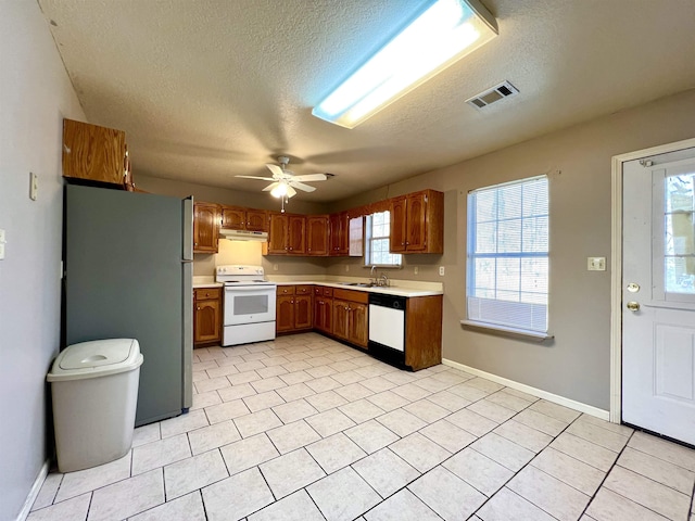 kitchen featuring visible vents, ceiling fan, under cabinet range hood, light countertops, and white appliances