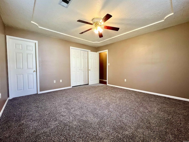 unfurnished bedroom featuring visible vents, a textured ceiling, and carpet flooring