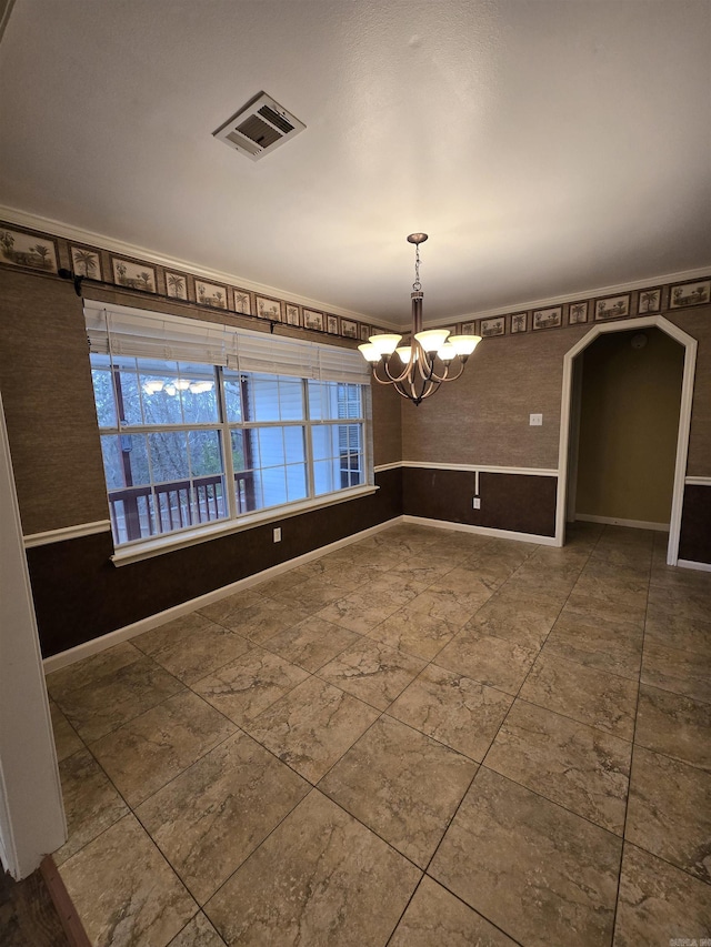 empty room featuring an inviting chandelier, baseboards, and visible vents