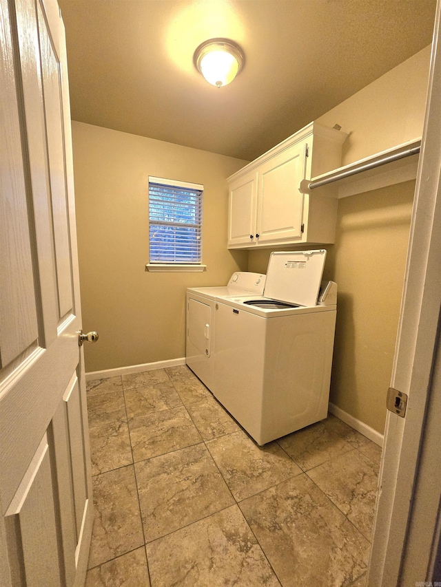 laundry area featuring baseboards, cabinet space, and separate washer and dryer