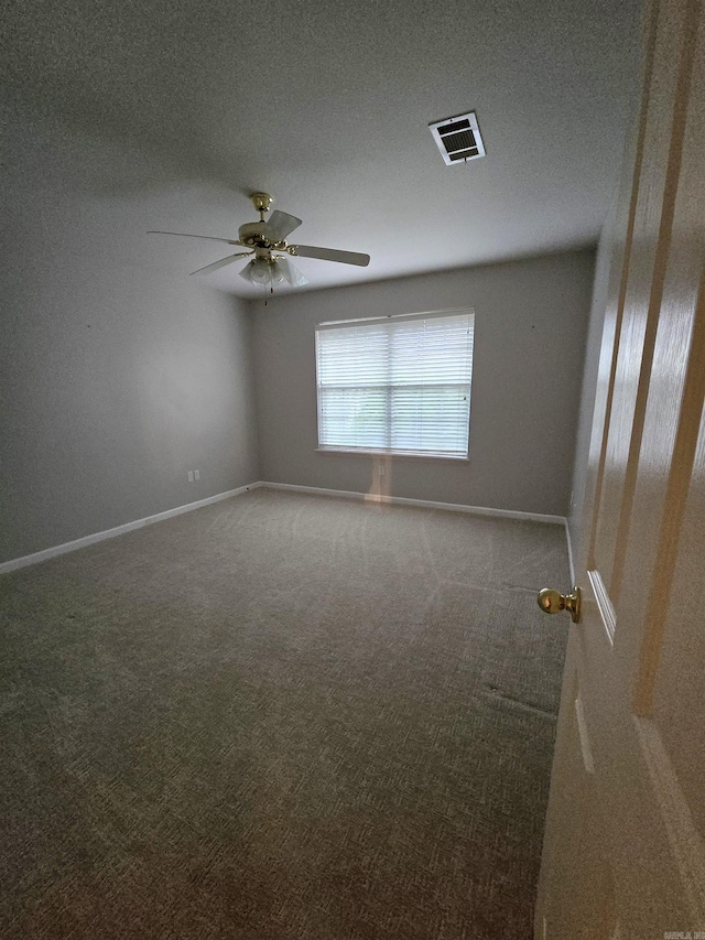 carpeted spare room with a ceiling fan, baseboards, visible vents, and a textured ceiling