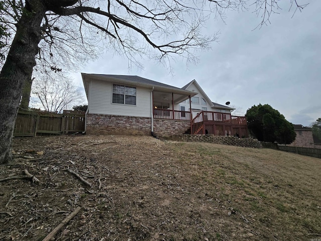 back of house featuring stairway, a yard, a wooden deck, and fence