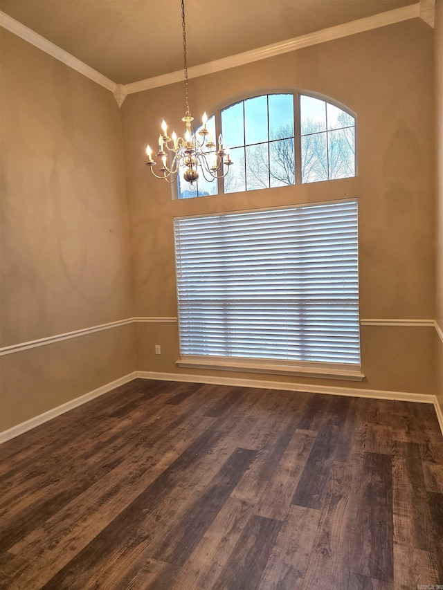 spare room featuring dark wood finished floors, crown molding, baseboards, and a chandelier