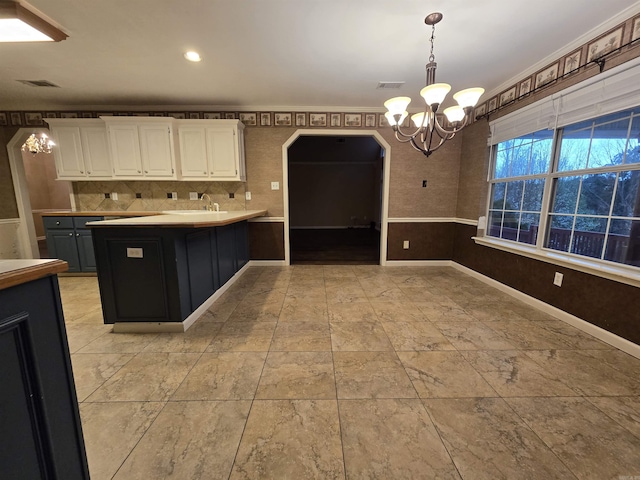 kitchen with a notable chandelier, pendant lighting, white cabinetry, and visible vents