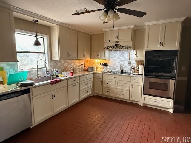 kitchen with appliances with stainless steel finishes, light countertops, a ceiling fan, and a sink