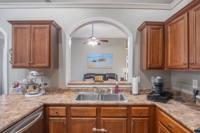 kitchen featuring a sink, brown cabinets, arched walkways, and a ceiling fan