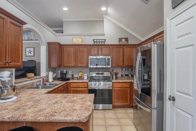 kitchen featuring a sink, stainless steel appliances, ornamental molding, and brown cabinetry