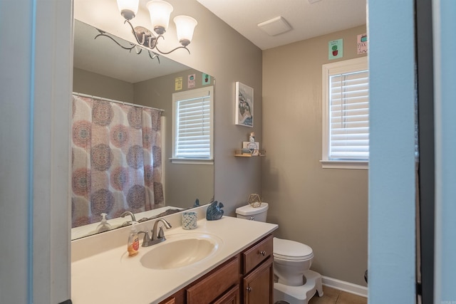 full bathroom with vanity, an inviting chandelier, toilet, and a healthy amount of sunlight